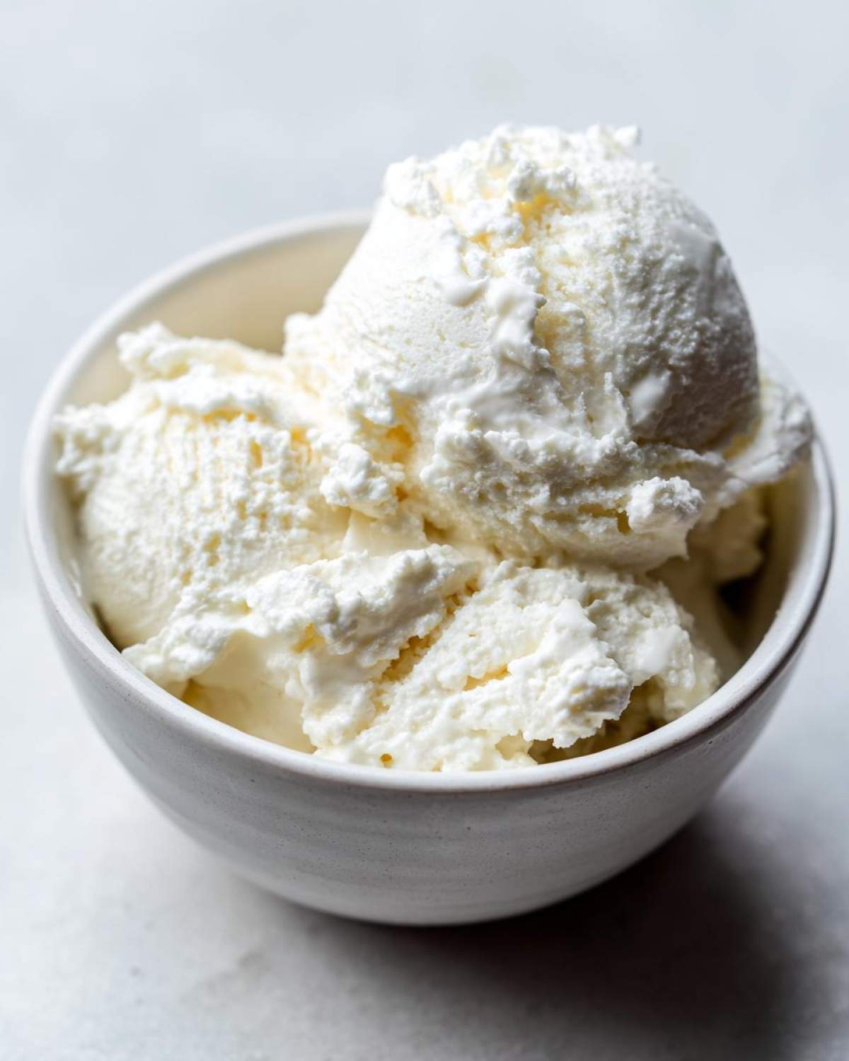 Close-up of a white bowl filled with scoops of high protein cottage cheese ice cream.