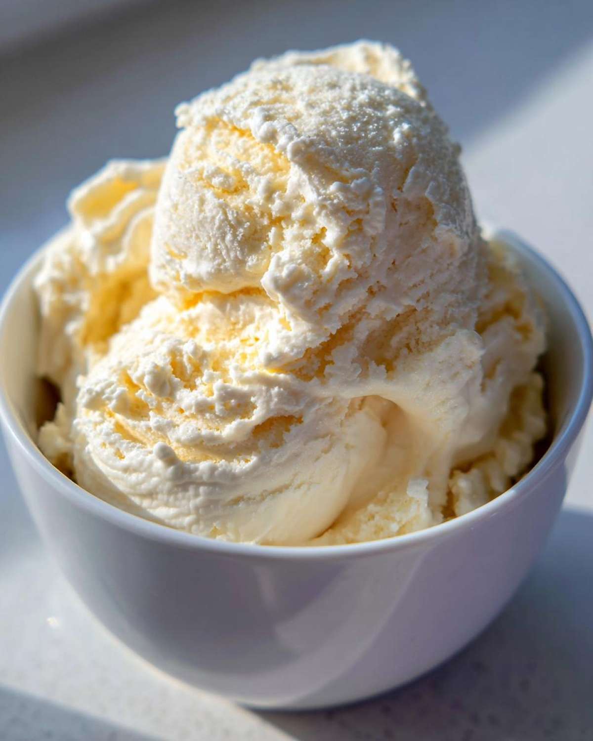 Close-up of a white bowl filled with scoops of high protein cottage cheese ice cream.