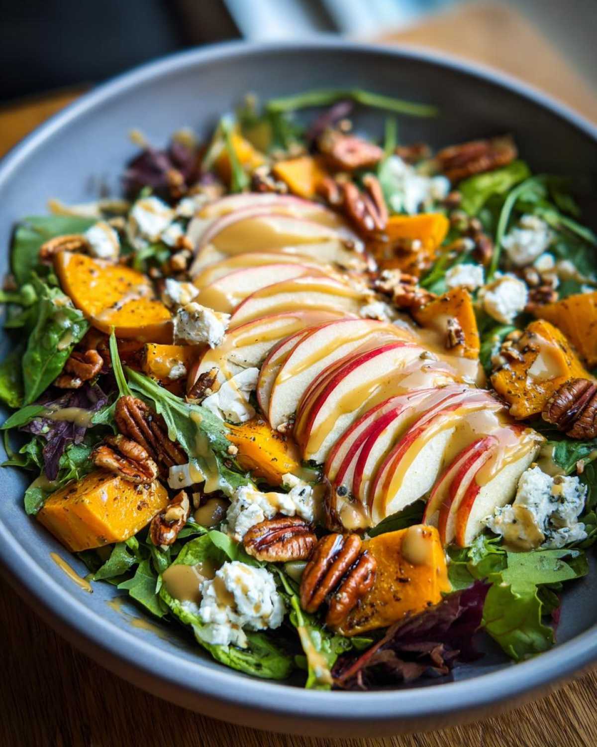 A vibrant fall salad with apples, butternut squash, pecans, and maple dressing. A perfect fall salad recipe.