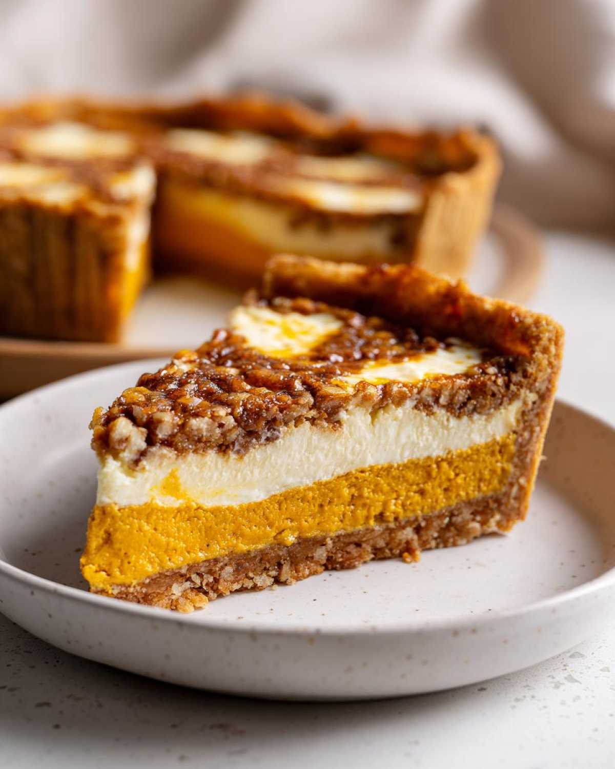 A slice of pumpkin crunch cake on a plate, showcasing the layered pumpkin, cream cheese, and crunchy topping.