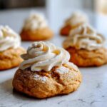 Close-up of pumpkin pie cookies topped with cream cheese frosting and a dusting of powdered sugar.