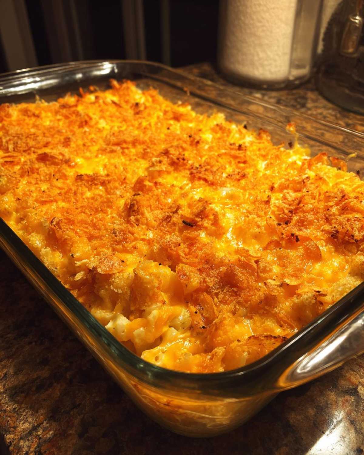 A close-up of a bubbly, golden hashbrown casserole with a crunchy, cheesy topping in a glass baking dish.