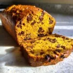 A sliced loaf of chocolate chip pumpkin bread, showcasing its moist texture and rich color.