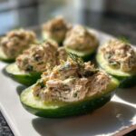 Cucumber tuna salad served in cucumber boats, garnished with dill.
