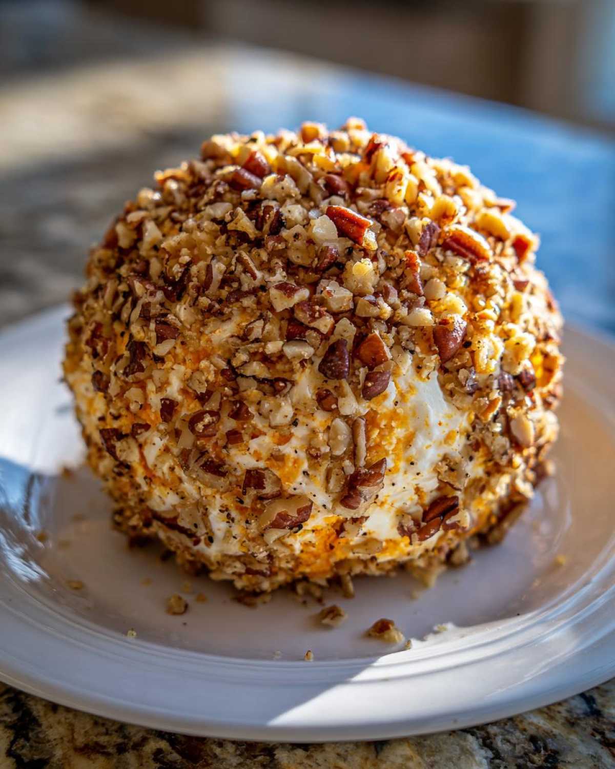 A delicious pumpkin cheese ball coated in chopped pecans, ready to be served.