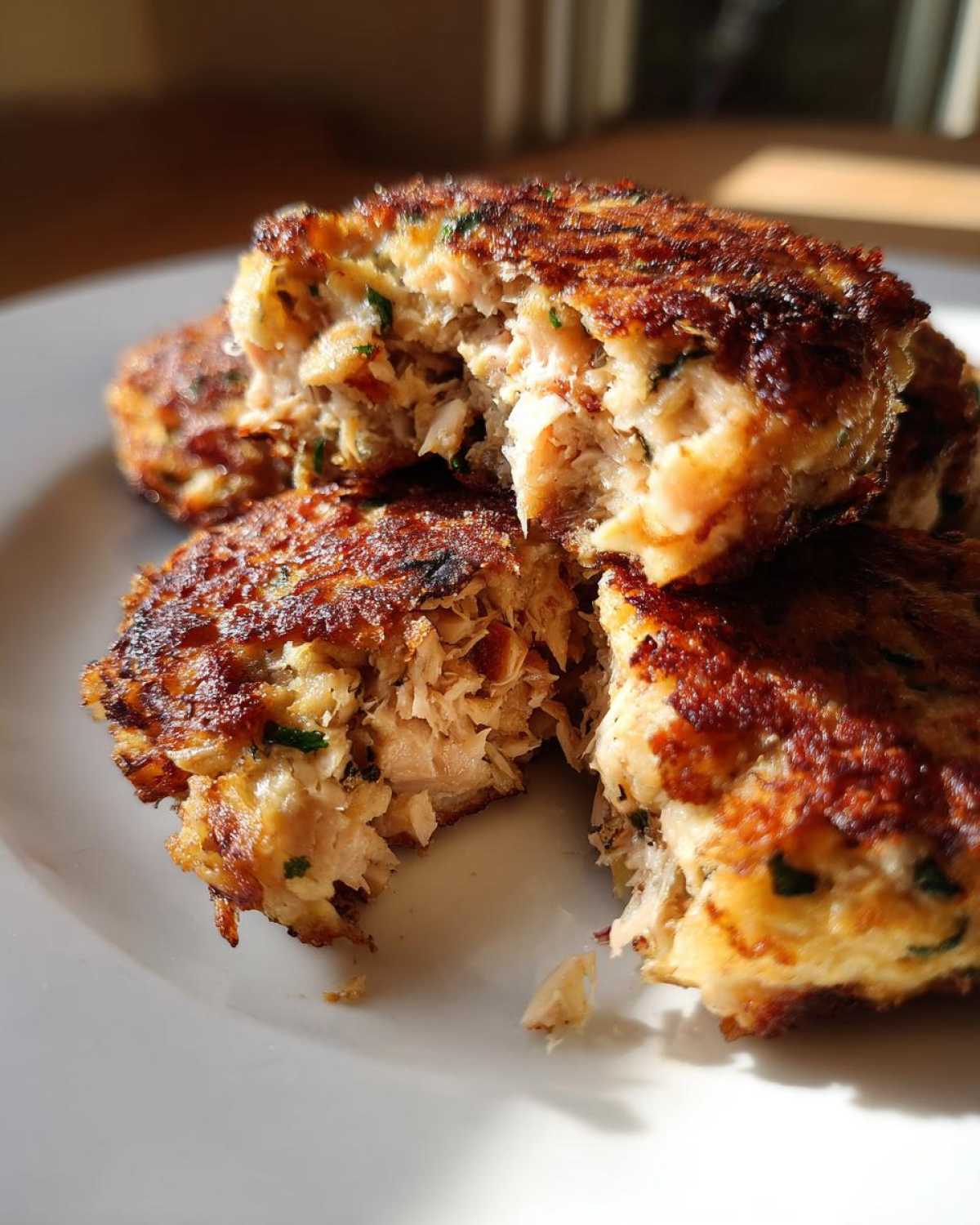 Close-up of air fryer tuna patties, one broken open to show the inside texture.