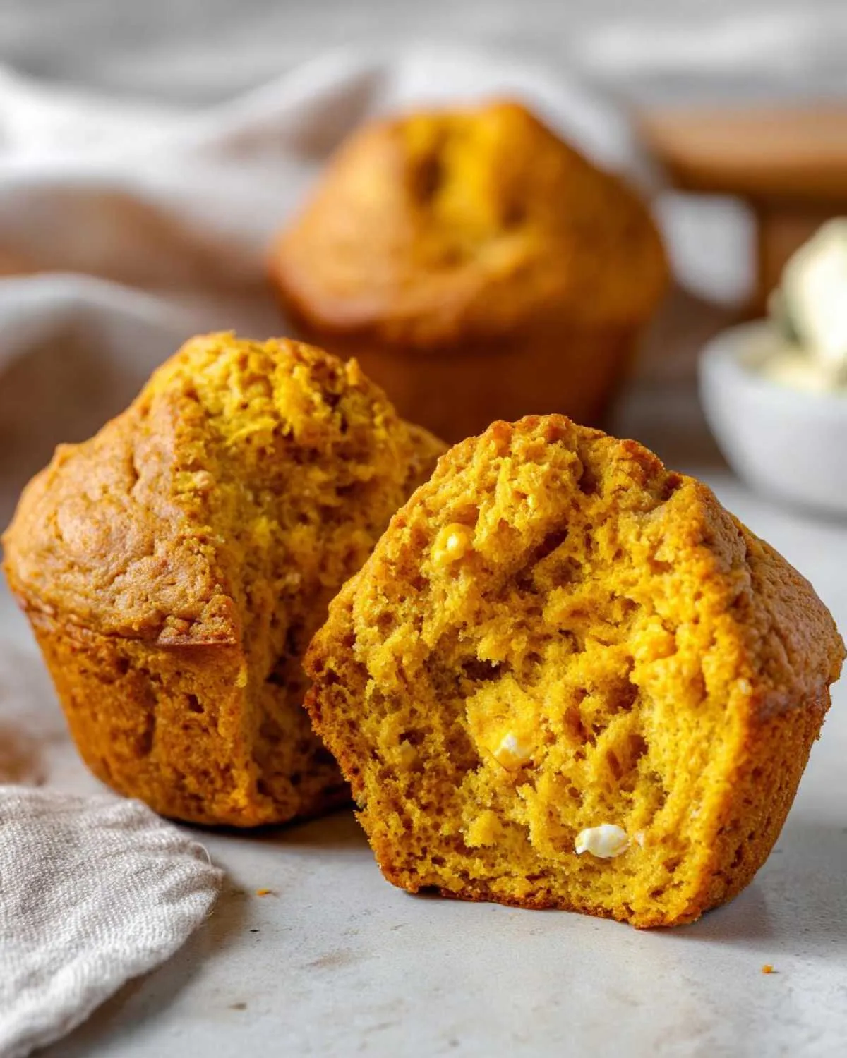 Close-up of a split cottage cheese pumpkin muffin, showing its moist interior with visible cottage cheese pieces.
