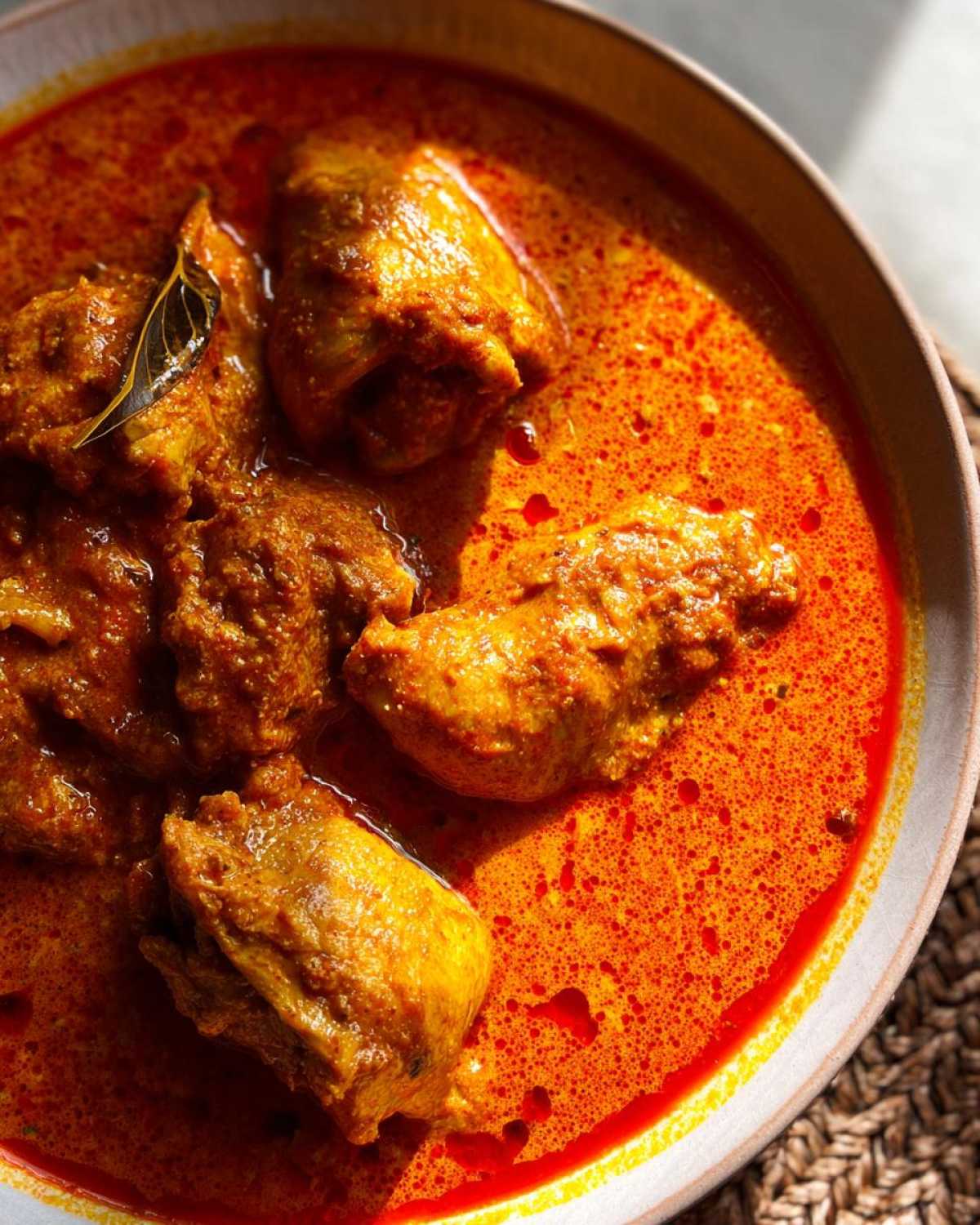Close-up of tender chicken pieces in a rich, creamy, orange sauce, a signature dish of crockpot butter chicken.