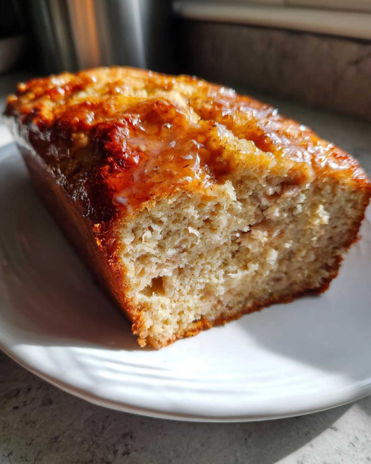A close-up of a slice of juicy garlic butter turkey meatloaf on a white plate.