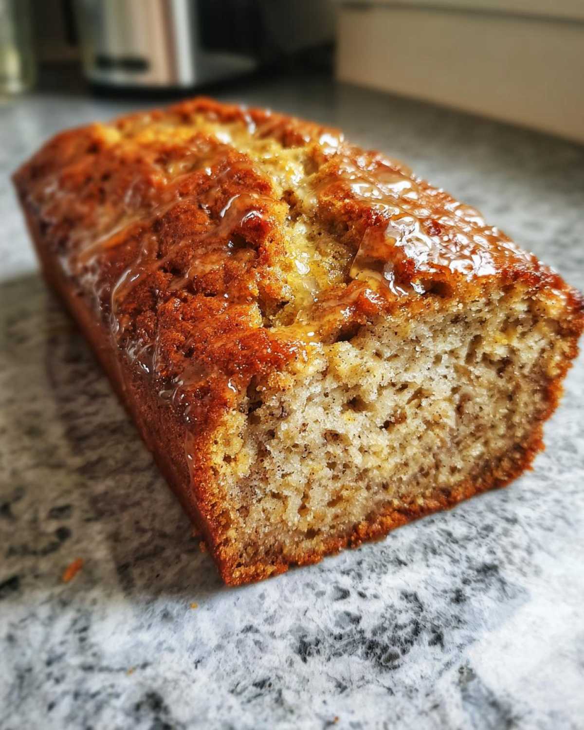 Close-up of a moist Honey Vanilla Banana Bread loaf with a glossy glaze.
