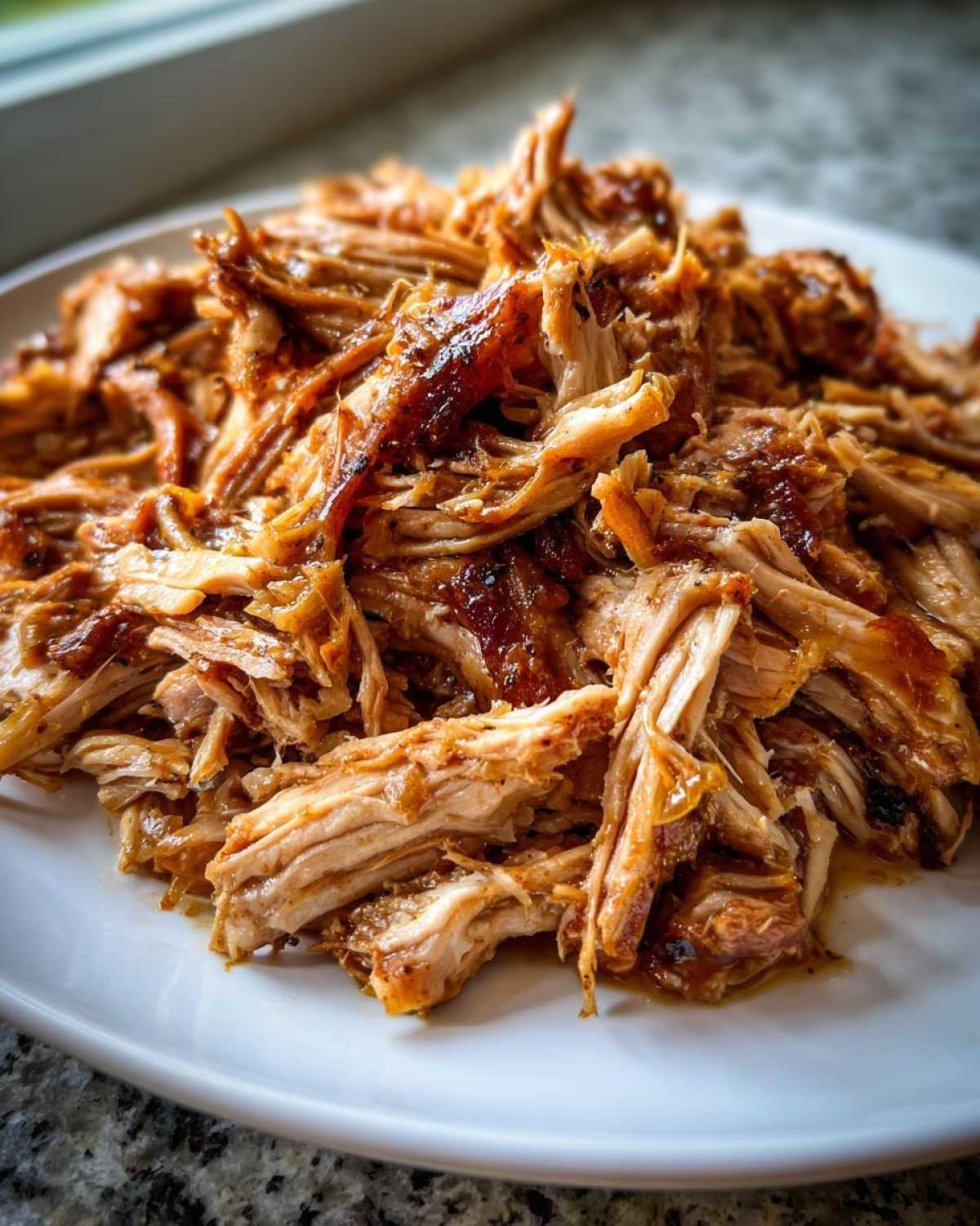 Close-up of a plate piled high with juicy, shredded pulled pork, a signature dish from The Pioneer Woman.