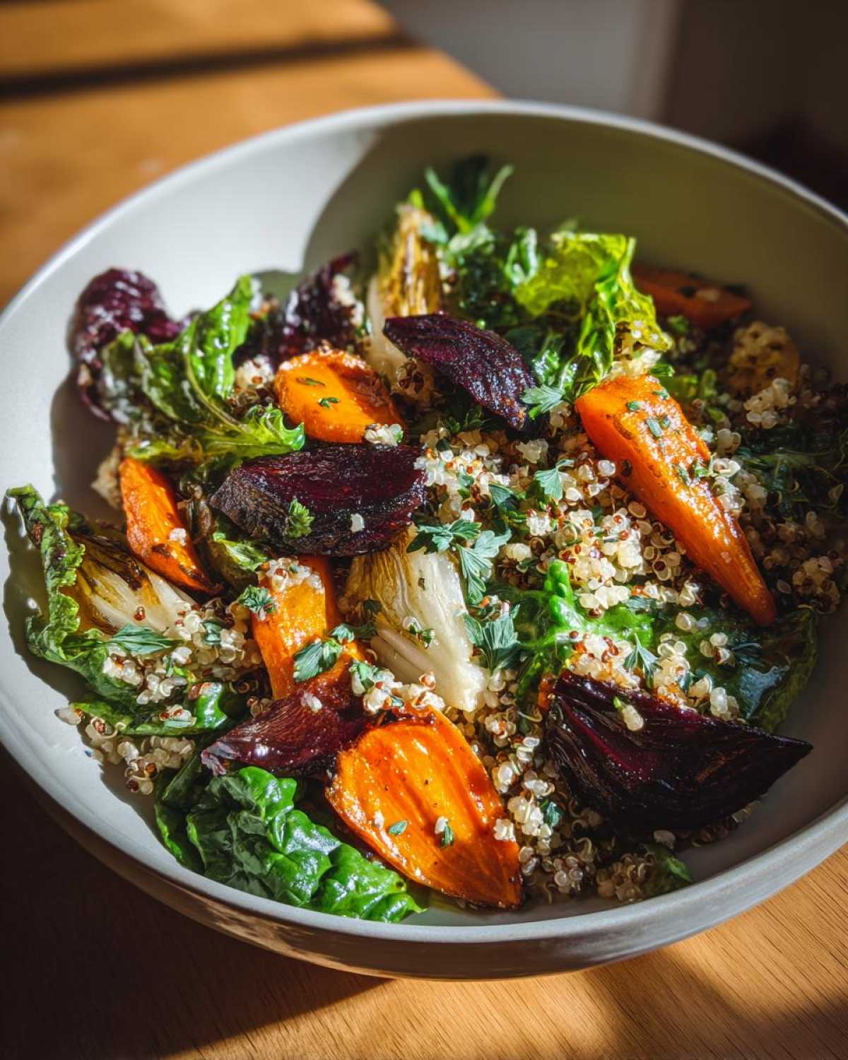 A vibrant plant powered greens salad bowl featuring roasted beets, carrots, and quinoa, topped with fresh herbs.
