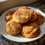 A pile of soft and chewy pumpkin cookies dusted with cinnamon sugar on a white plate.