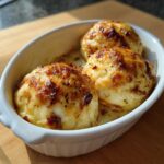 Three creamy Starbucks egg bites with a golden-brown, cheesy top, served in a white oval dish.