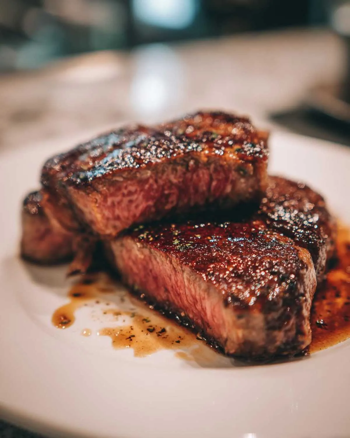 Close-up of perfectly cooked steak slices, showcasing a juicy interior and rich marinade.