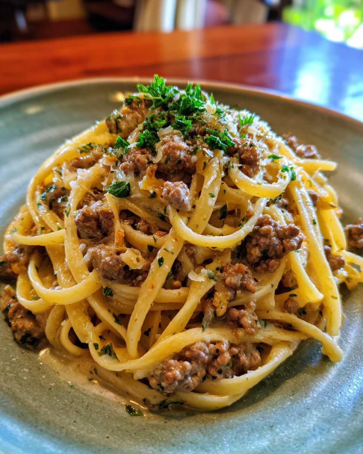A delicious close-up of Beef and Garlic Butter Linguine, garnished with fresh parsley and grated cheese.