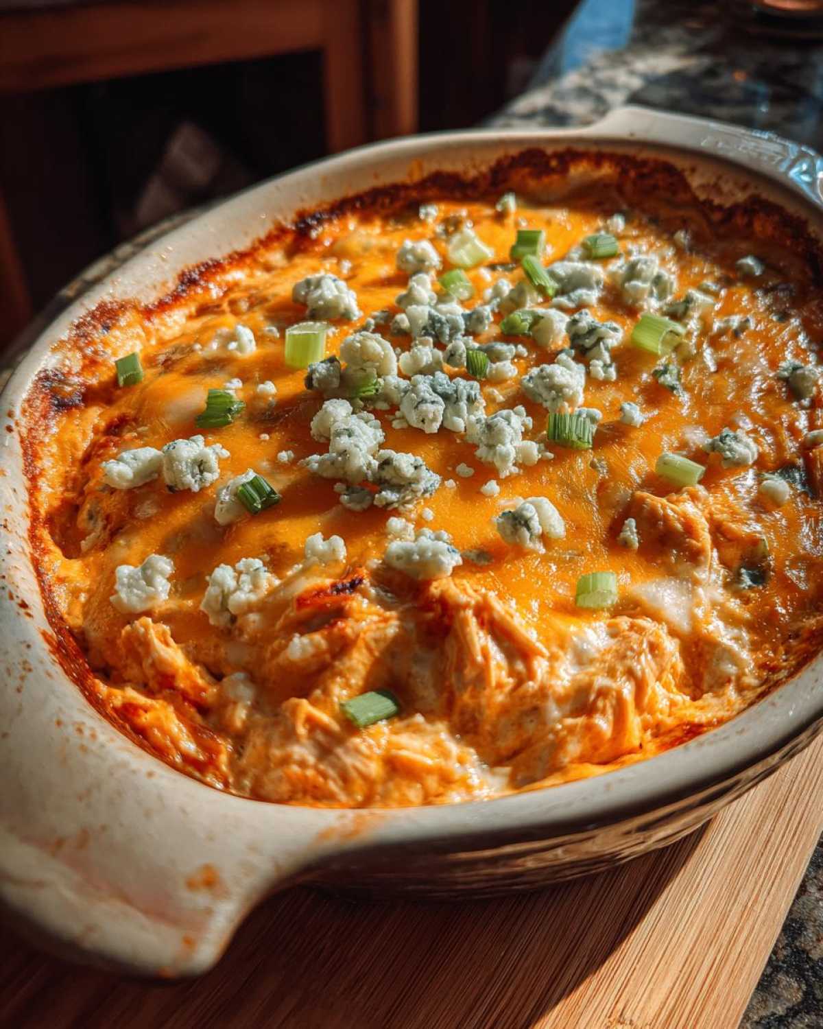 A bubbling hot classic buffalo chicken dip, topped with crumbled blue cheese and chopped green onions.