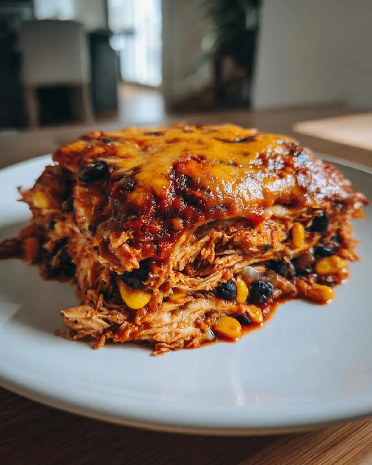 A hearty slice of crockpot chicken enchilada casserole with shredded chicken, black beans, corn, and melted cheese.