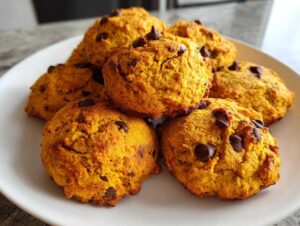 A plate of soft and chewy gluten-free pumpkin cookies loaded with chocolate chips.