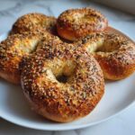 A plate of freshly baked Greek yogurt bagels topped with everything seasoning, ready to be enjoyed.