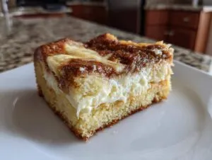 A close-up of a slice of Neiman Marcus cake, showcasing its layers of cake, creamy filling, and chocolatey topping.