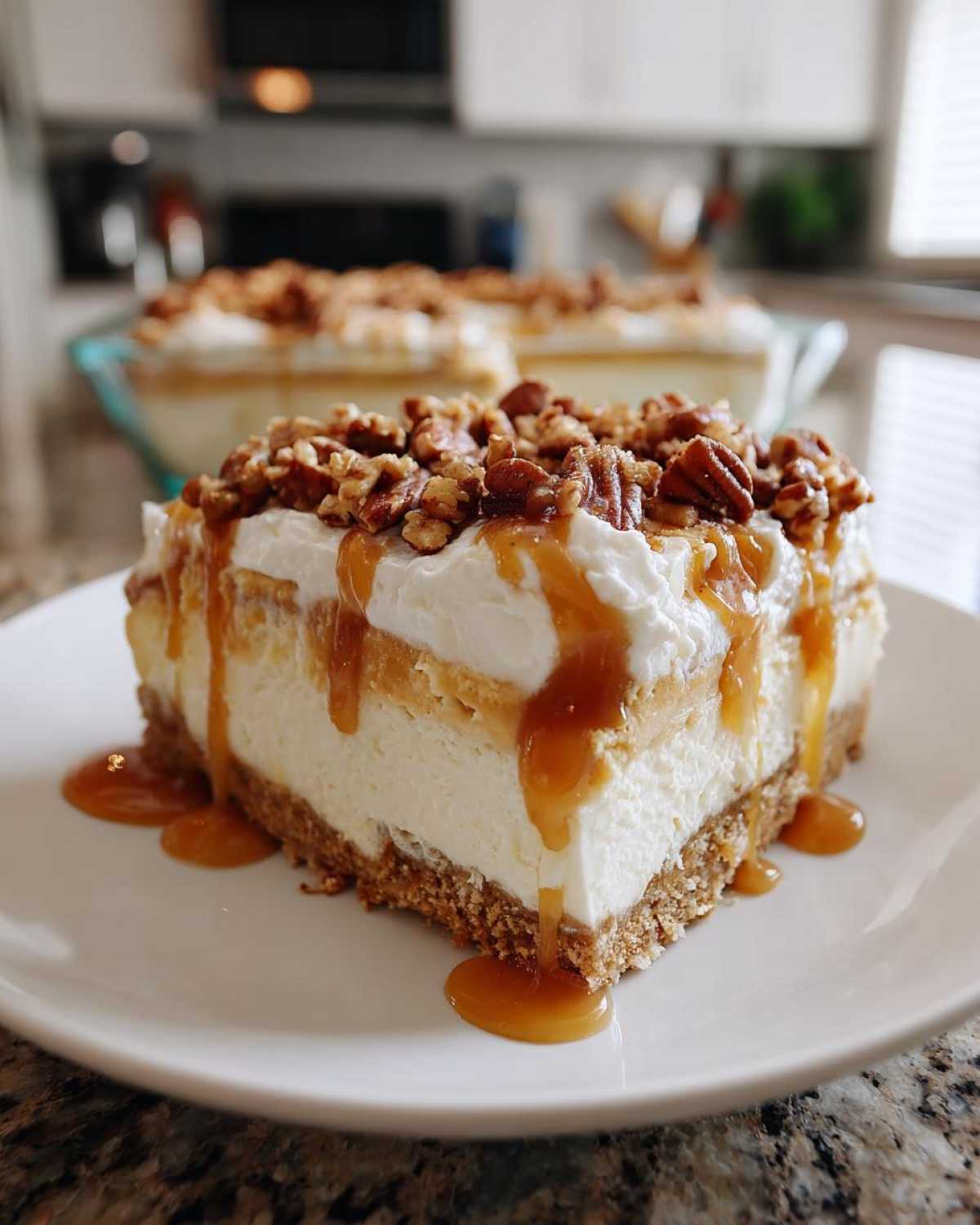 A slice of Pumpkin Cheesecake Lasagna topped with whipped cream, pecans, and caramel drizzle.