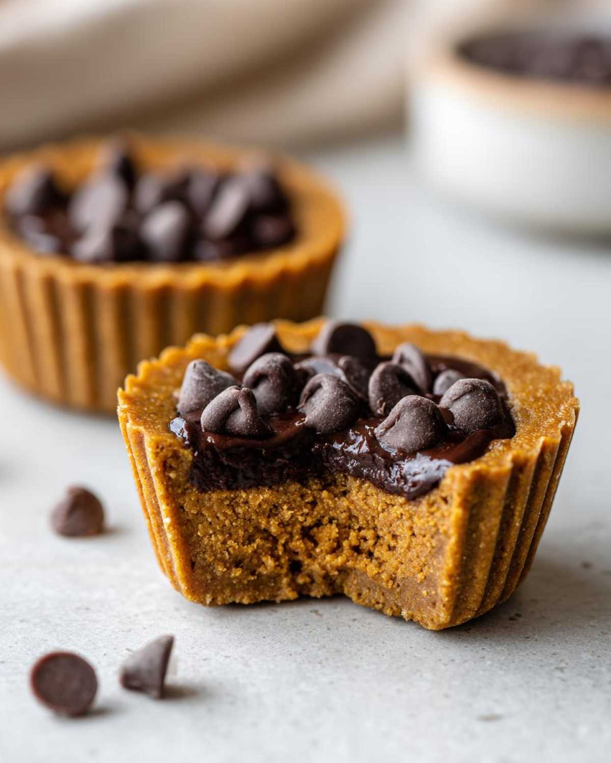 Close-up of a Pumpkin Protein Cup with a bite taken out, topped with chocolate chips.