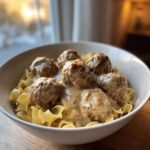 A bowl of delicious slow cooker Swedish meatballs in creamy sauce served over egg noodles.