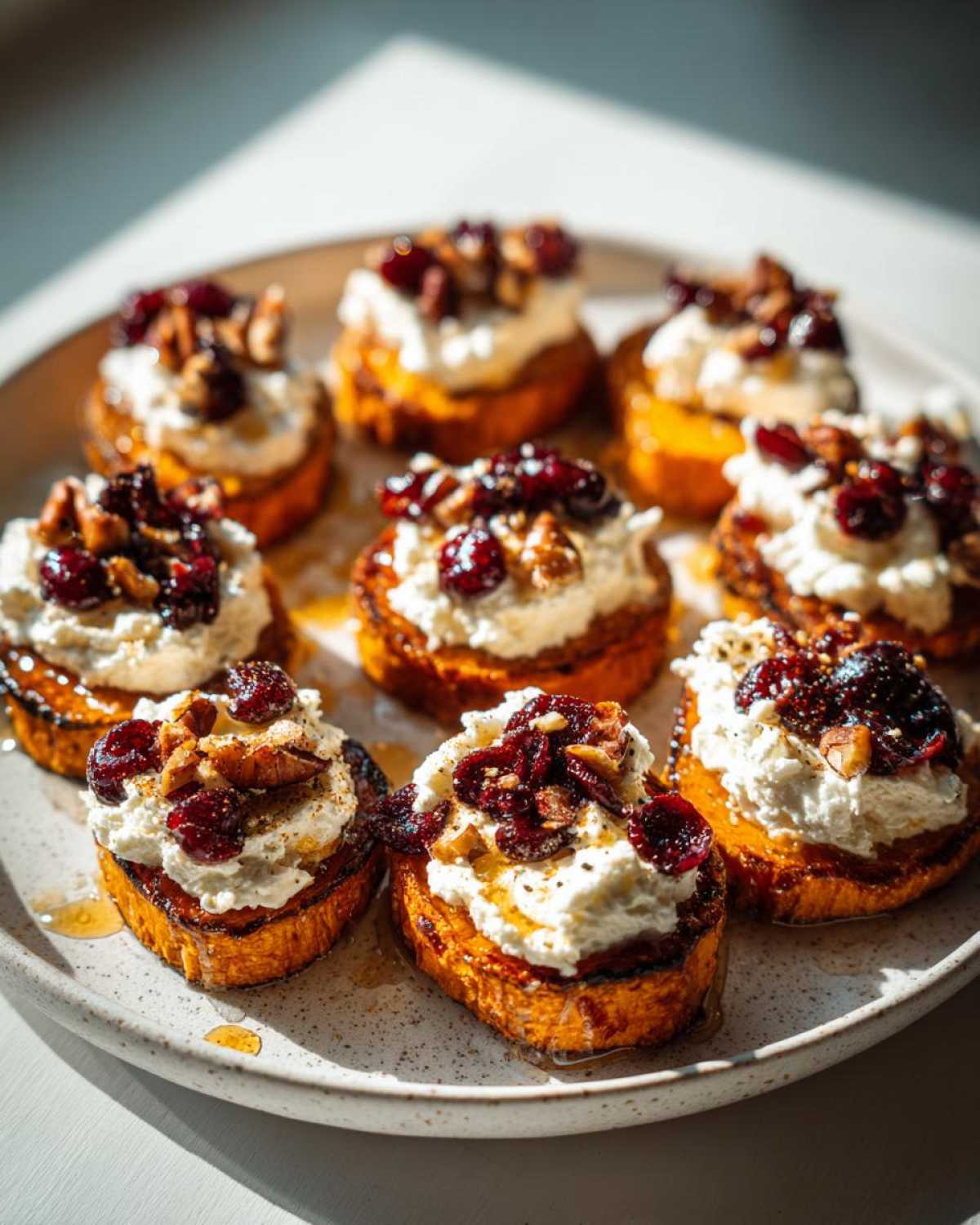 Crispy sweet potato rounds topped with creamy goat cheese, dried cranberries, toasted pecans, and a drizzle of honey.