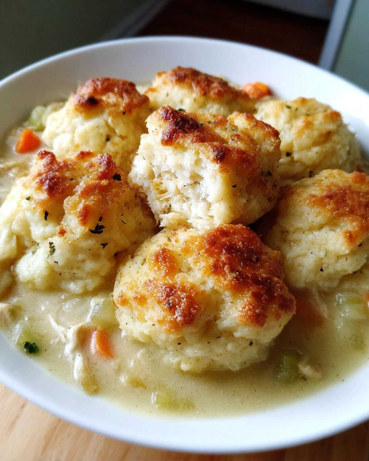 Close-up of fluffy, golden-topped dumplings served atop a creamy chicken and vegetable stew. These are amazing 35 minute dumplings.