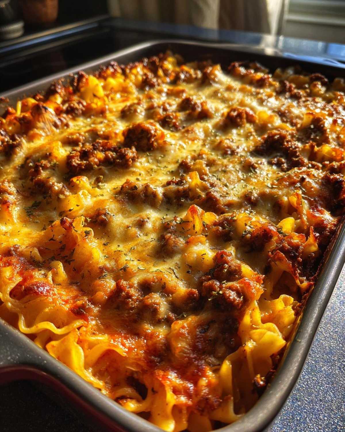 Close-up of a freshly baked Amish country casserole in a baking dish, with golden melted cheese and ground meat topping.