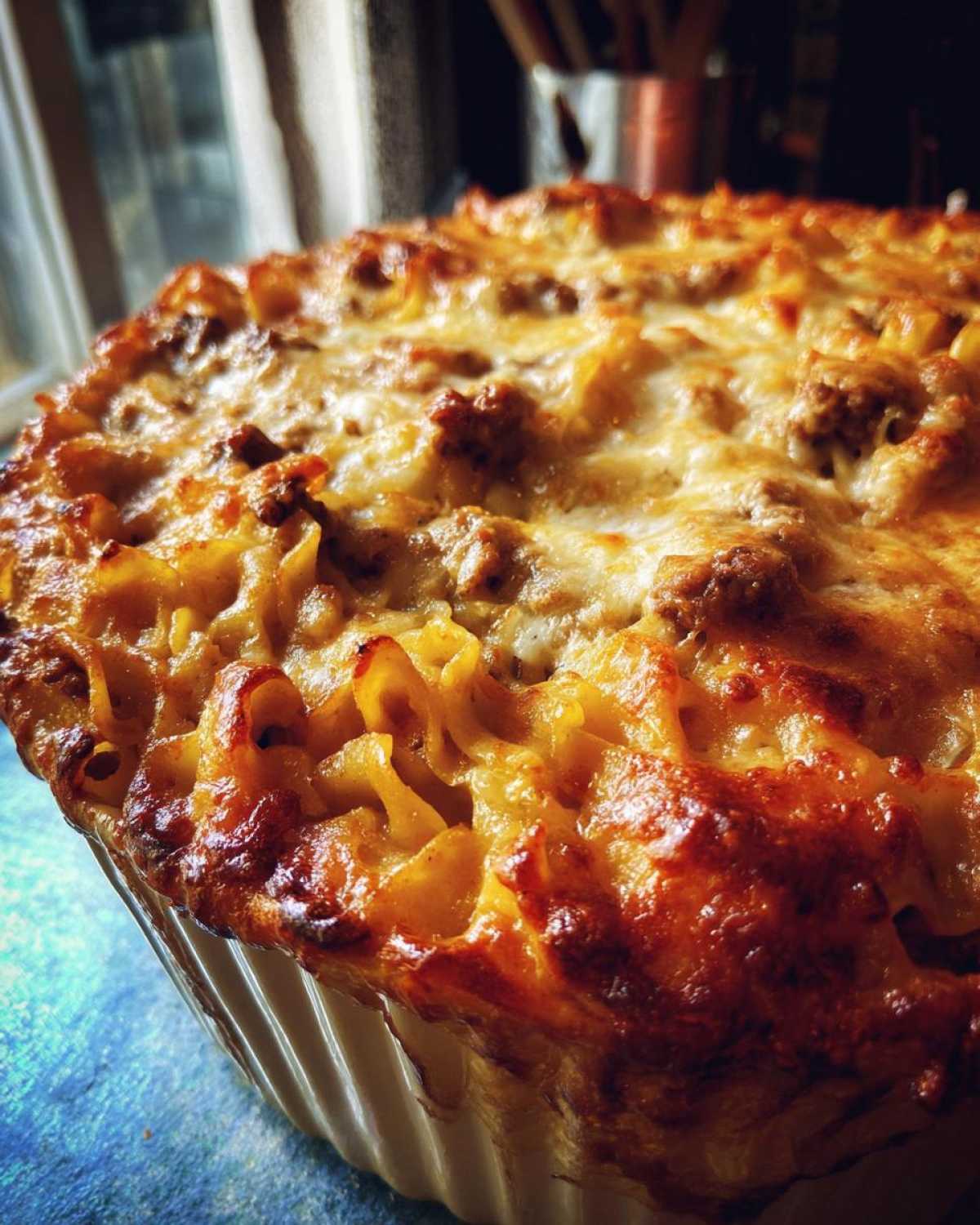 Close-up of a golden-brown Amish country casserole with melted cheese and pasta.