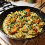 A close-up of Artichoke Chicken Piccata in a skillet, garnished with fresh parsley.