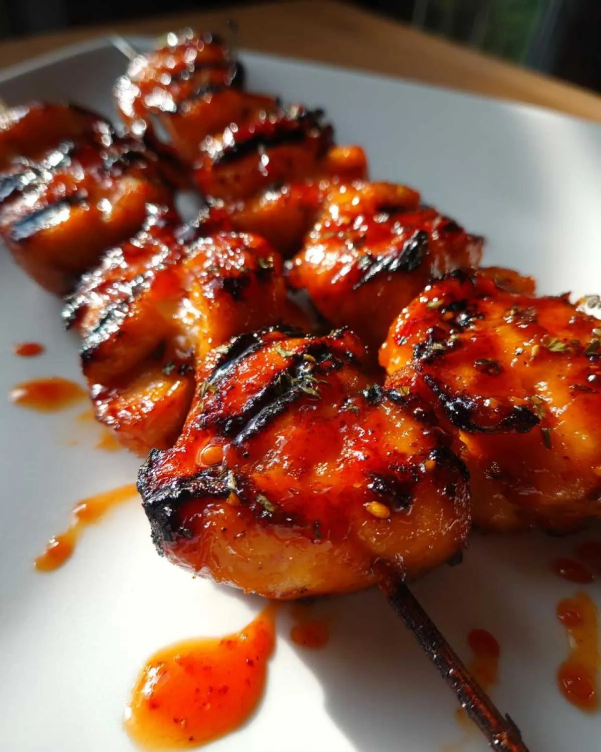 Close-up of juicy Bang Bang chicken skewers glazed with a spicy sauce, grilled to perfection.