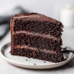 A decadent slice of black velvet halloween cake with rich chocolate frosting and layers.