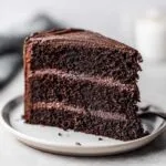 A decadent slice of black velvet halloween cake with rich chocolate frosting and layers.