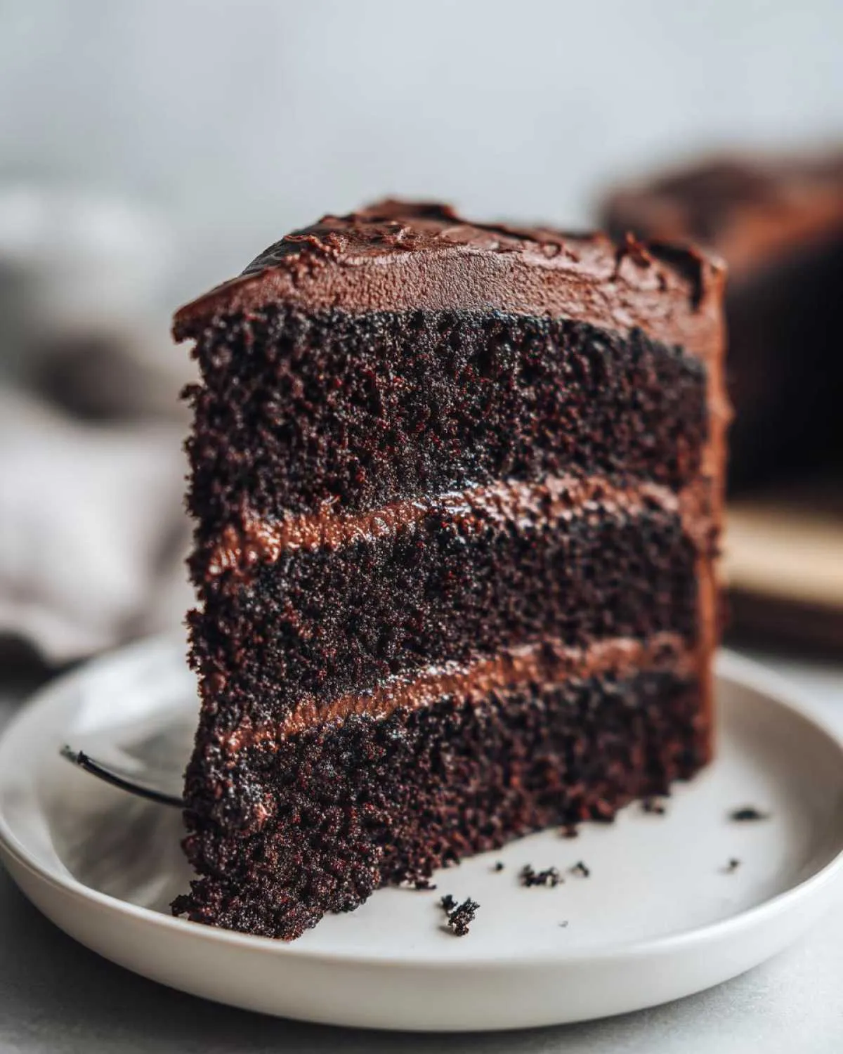 A moist slice of black velvet Halloween cake with rich chocolate frosting and layers.