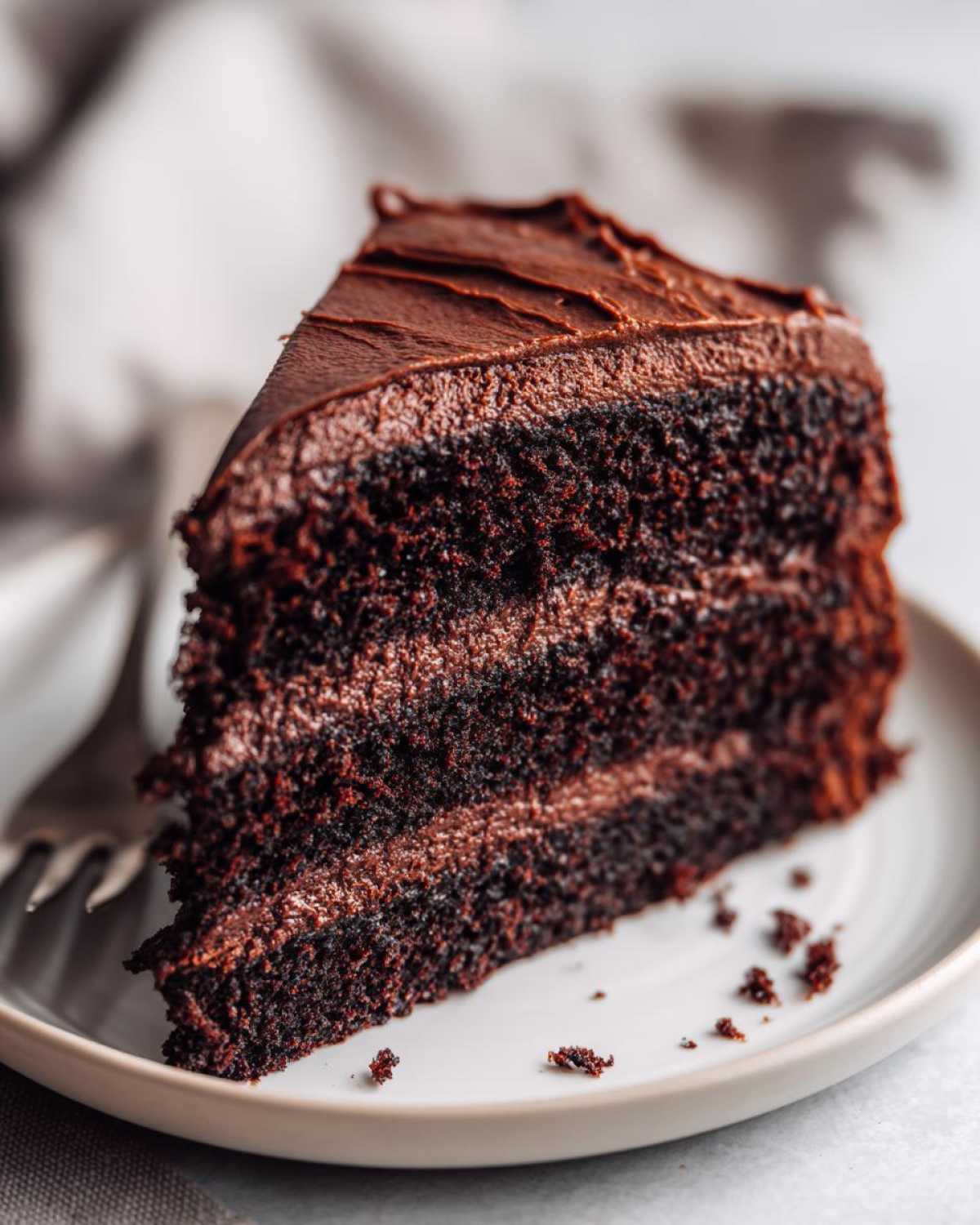 A decadent slice of black velvet halloween cake with rich chocolate frosting and layers.