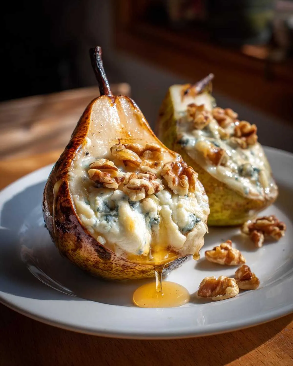 Close-up of baked blue cheese stuffed pears drizzled with honey and topped with walnuts.