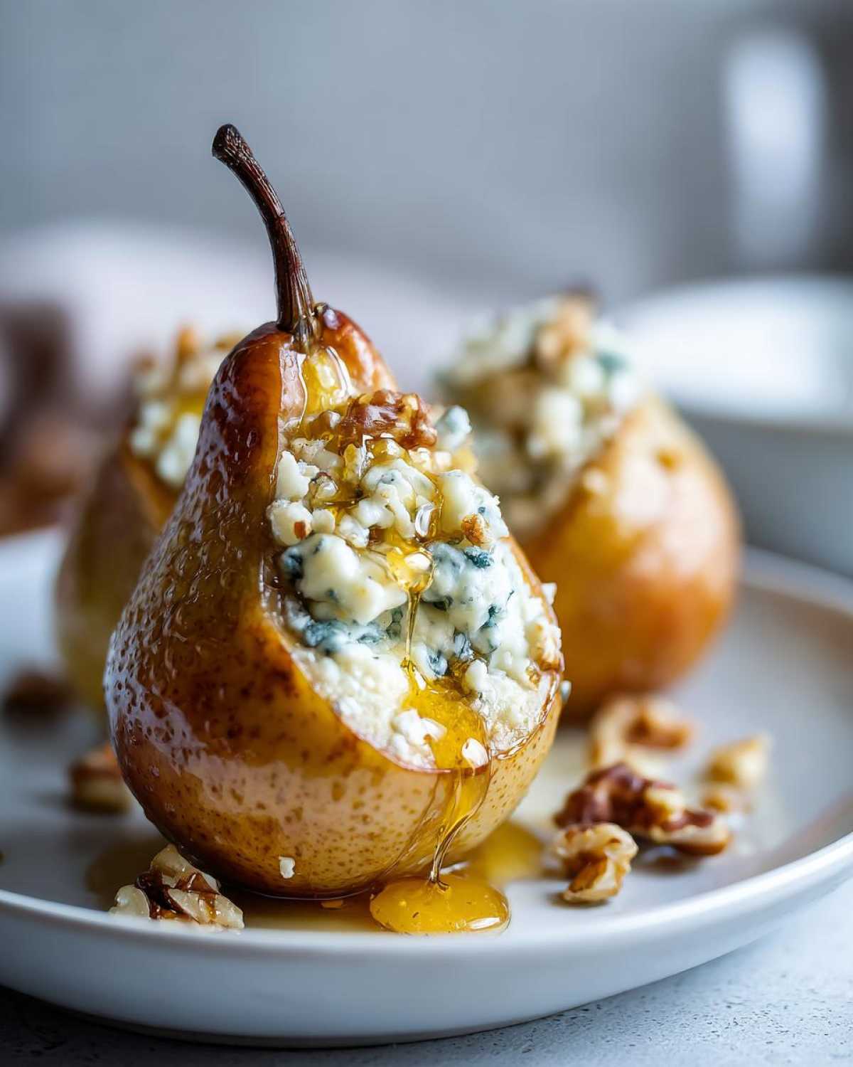 Close-up of a baked pear stuffed with blue cheese and walnuts, drizzled with honey.