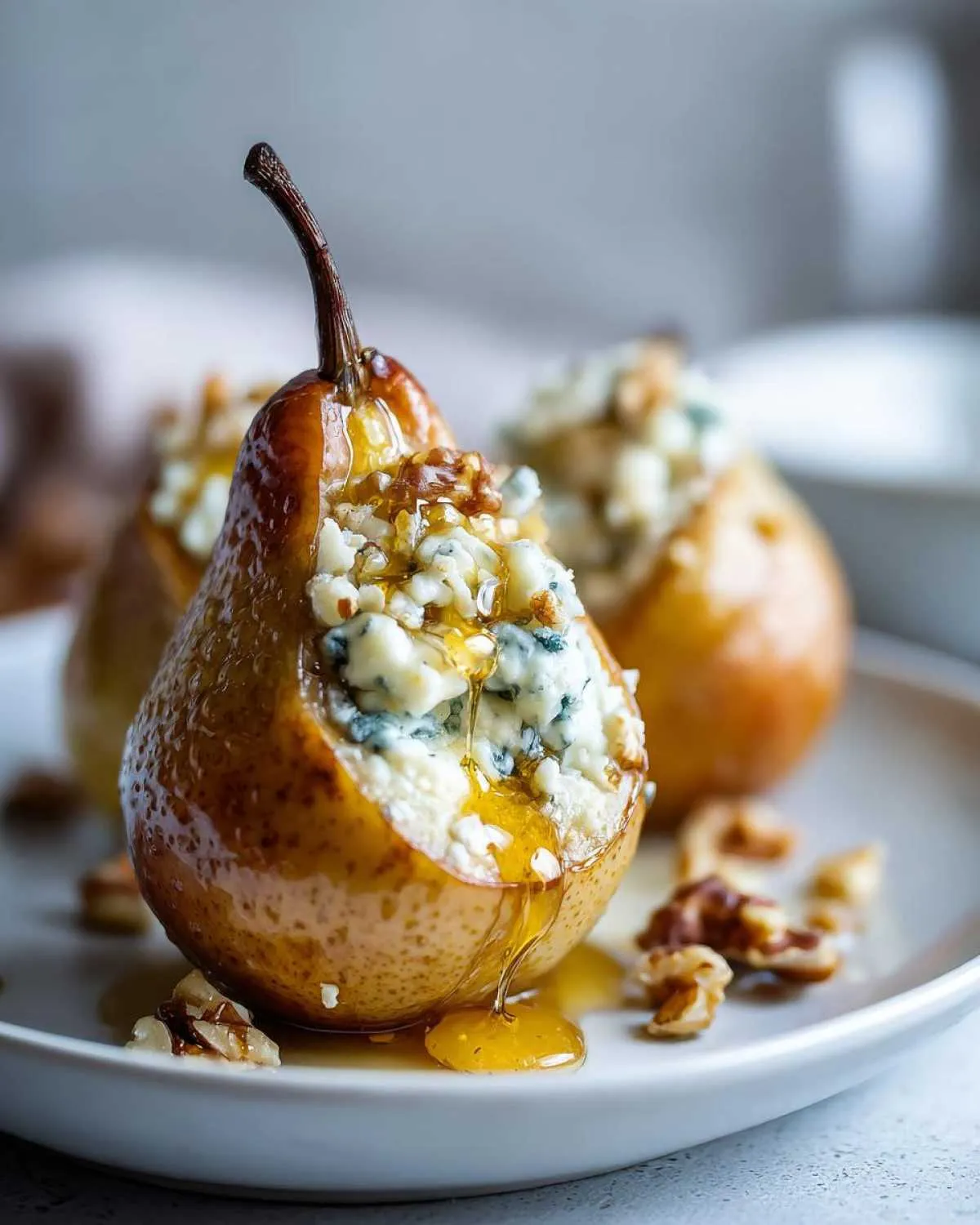 Close-up of a baked pear stuffed with blue cheese and walnuts, drizzled with honey.