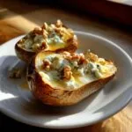 Two halves of baked pears stuffed with creamy blue cheese and topped with crunchy walnuts.