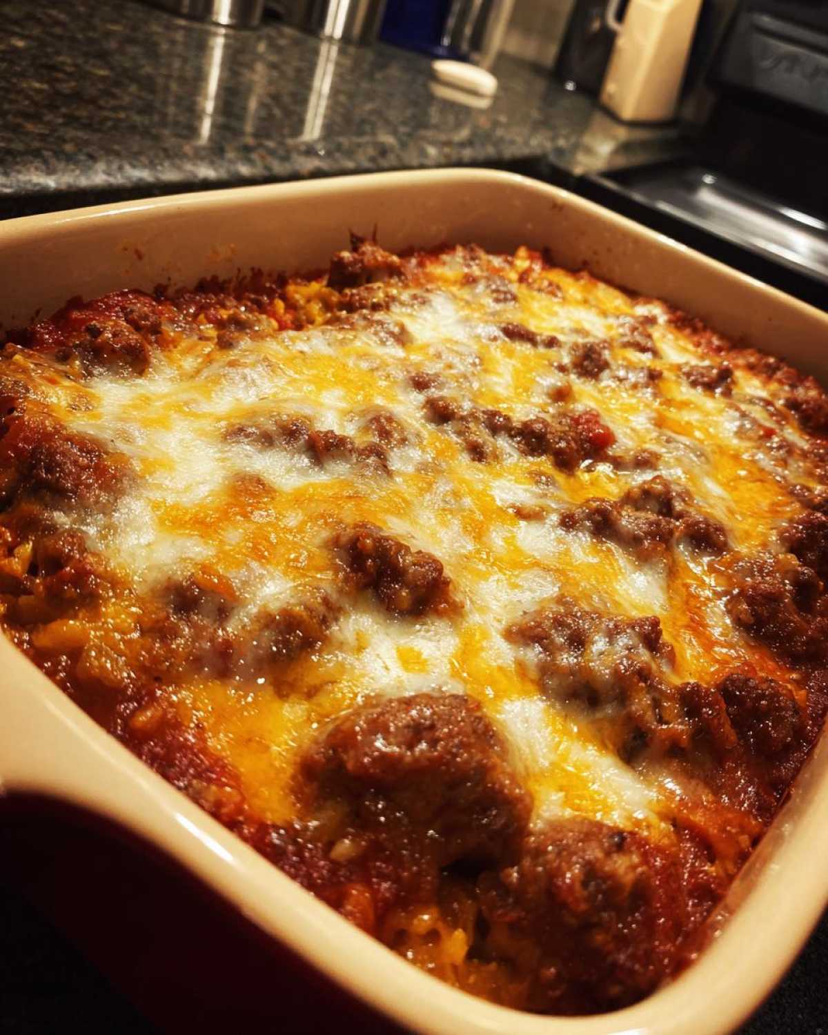 Close-up of a freshly baked cabbage beef bake in a casserole dish, topped with melted cheese.