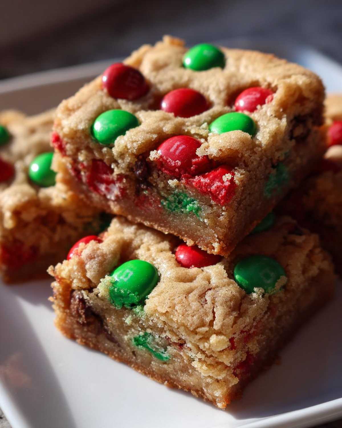 Close-up of stacked Christmas cookie bars studded with red and green M&Ms.