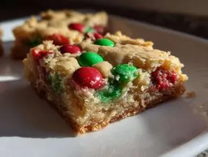 Close-up of a Christmas cookie bar loaded with red and green M&Ms, perfect for holiday baking.