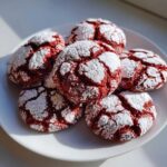 A pile of festive red christmas crinkle cookies from cake mix, dusted with powdered sugar.