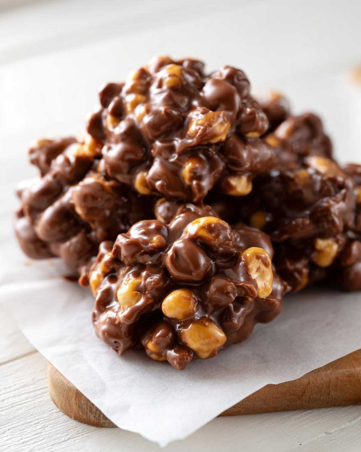 A close-up of delicious Crockpot candy clusters, made with melted chocolate and peanuts.