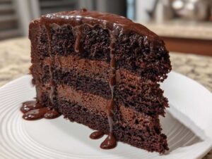 A decadent slice of Death by Chocolate Cake with rich chocolate frosting and ganache.