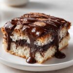 A moist slice of chocolate pudding cake with a gooey chocolate sauce dripping down the sides.