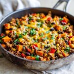 Close-up of a Southwest Turkey Sweet Potato Skillet topped with melted cheese and fresh cilantro.